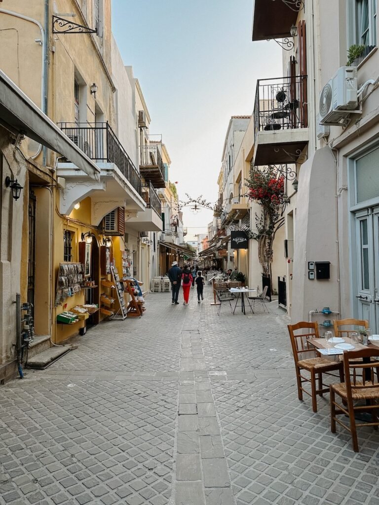 Charming streets of Chania, Greece, lined with colorful buildings, cobblestone paths, and a mix of locals and travelers exploring the historic town.