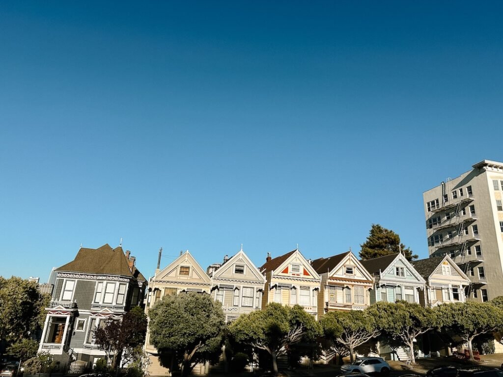 View of the Painted Ladies in San Francisco, showcasing the iconic Victorian houses with a scenic backdrop of the city skyline.
