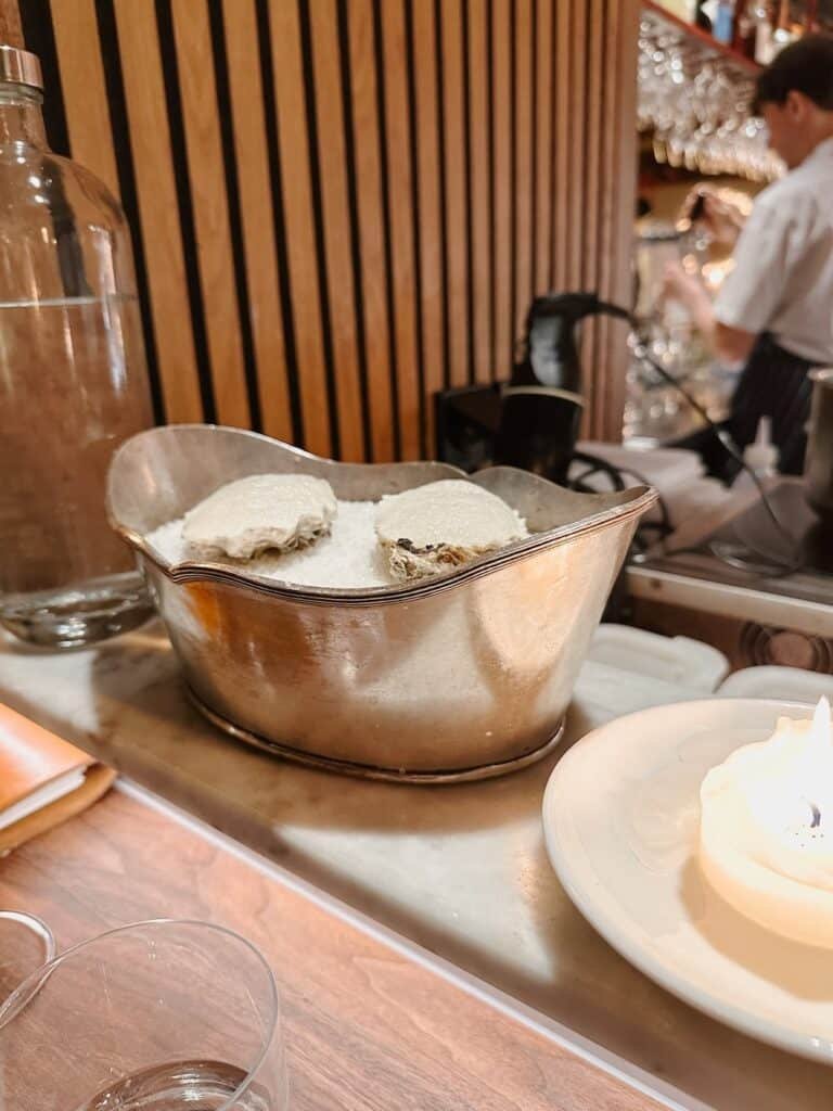 Fresh oysters on ice with a glass of white wine at a seafood bar in Amsterdam