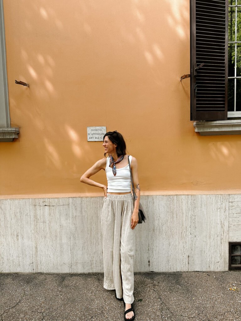Posing in front of a bold, orange-colored wall in Rome, capturing the warm hues of the city’s architecture and the essence of spring in Italy