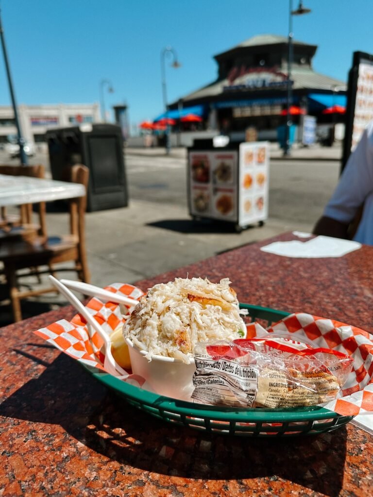 A steaming bowl of fresh Dungeness crab, served with melted butter and lemon at a seafood stand in Fisherman’s, a must-do for first-time visitors in San Francisco.