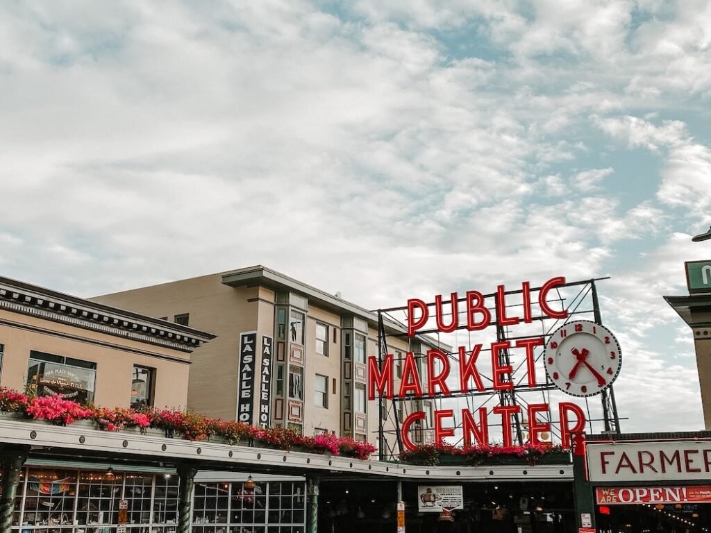 The iconic red neon sign at Pike Place Market in Seattle, a must-visit spot for food lovers and first-time visitors