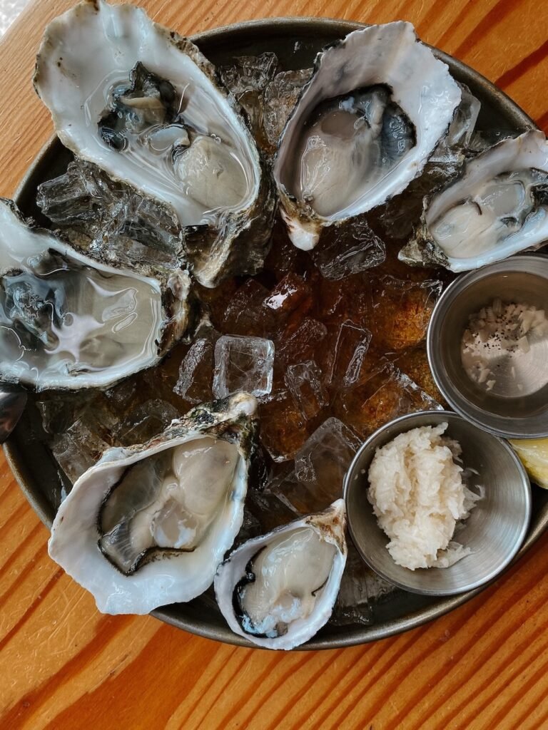 Freshly shucked oysters on a bed of ice, served with lemon wedges and mignonette sauce at a Seattle oyster bar.